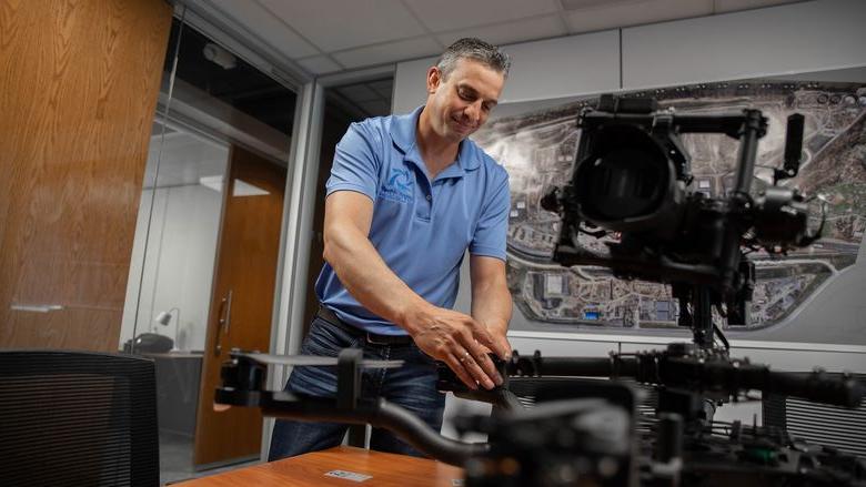 Man touching drone on table